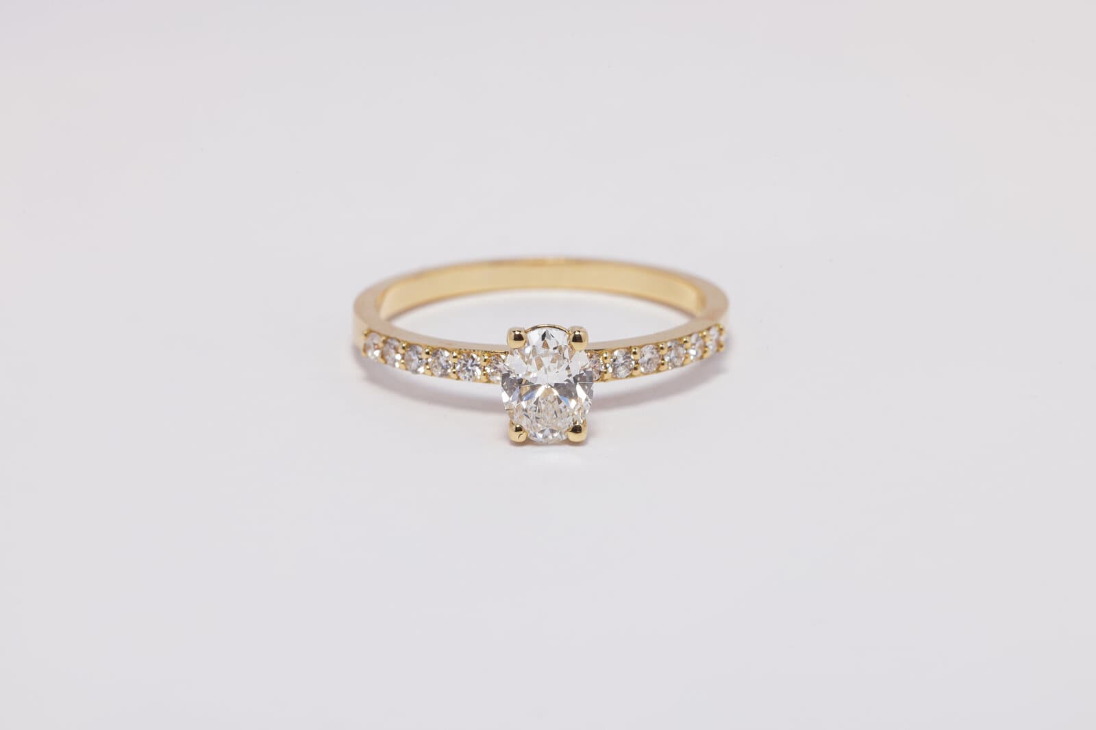 A delicate solitaire oval ring with a diamond band