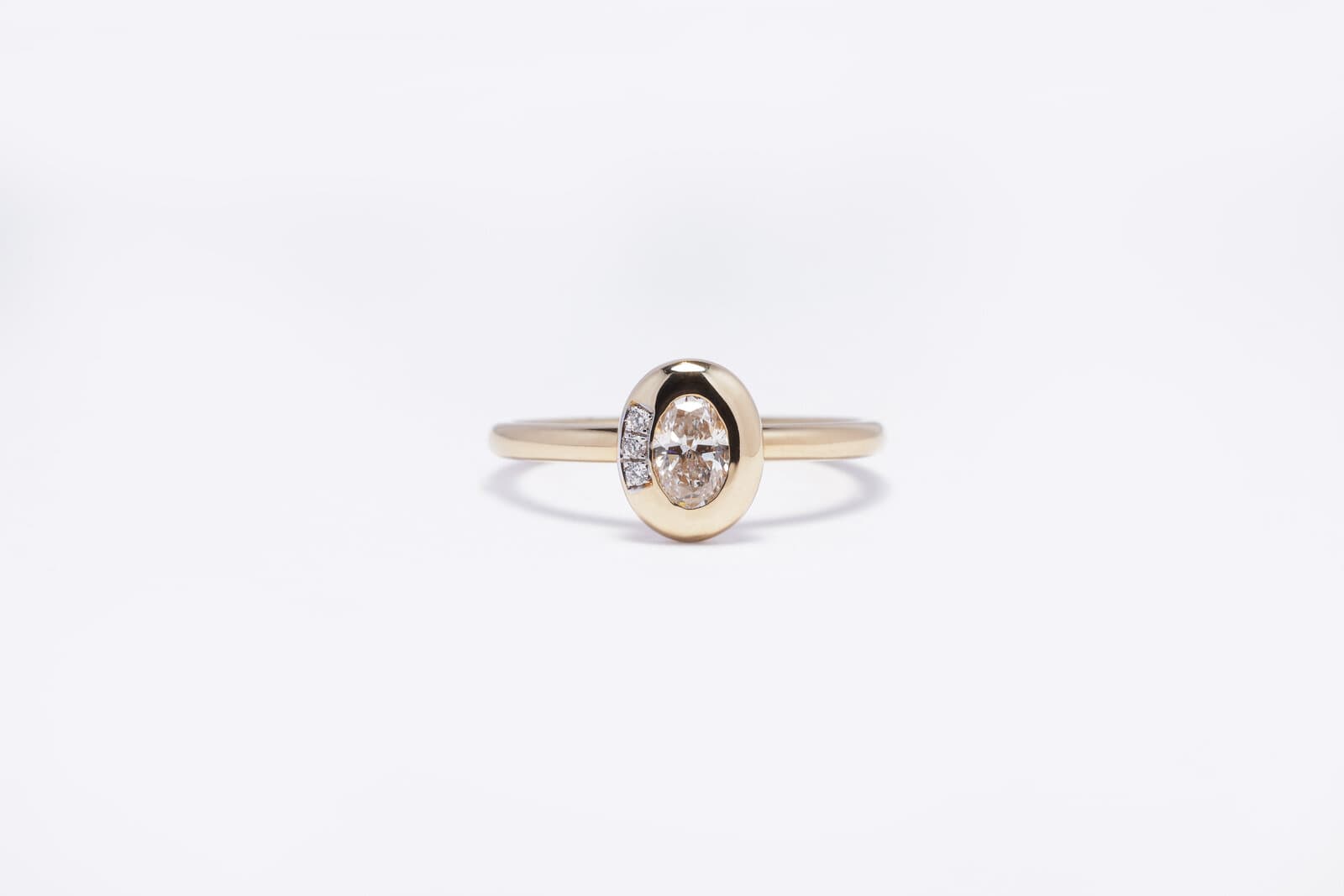 A sleek yellow gold ring featuring an oval center diamond - 2